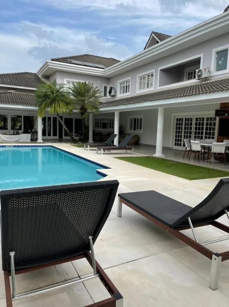 Vista da fachada pelos fundos com piscina generosa